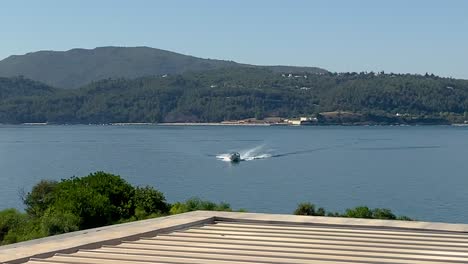 Ultra-wide-top-down-photo-of-luxury-rigid-inflatable-speed-boat-cruising-in-high-speed-in-Troia-beauty-blue-sea,-Portugal