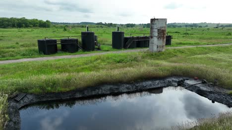 Oil-retention-pond-and-tanks-holding-crude-oil-at-pumping-site-with-wells