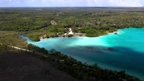 Descending-drone-shot-of-people-enjoying-the-clear-blue-water-at-Bacalar-Mexico