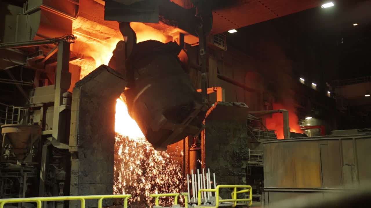 Intense steel mill scene with molten metal being poured from a ladle in a foundry