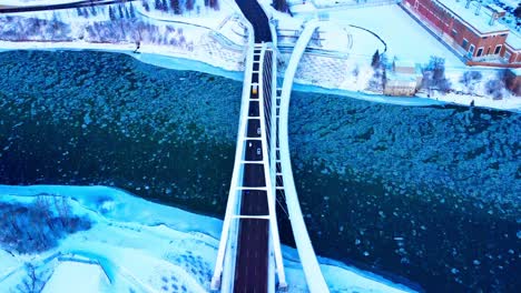 school bus crossing walter dale bridge aerial flyover panoramic pan out dolly roll as skyline reveals the downtown edmonton city skyscrapers in the capital of alberta canada winter snow covered 2-2