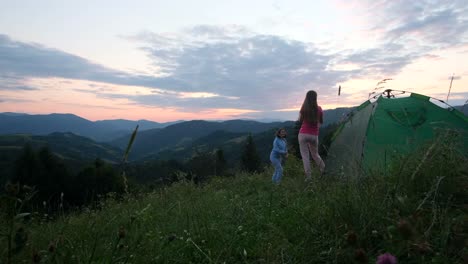 two young girls in white dresses are photographed on top of a mountain two young girls in white dresses are photographed on top of a mountain with clouds in the background