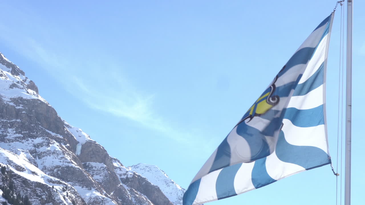 스위스 grisons 광저우 깃발 흔들며 배경 눈 덮인 산 4k 영상