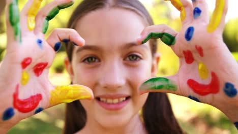 happy girl with hands painted in water colors