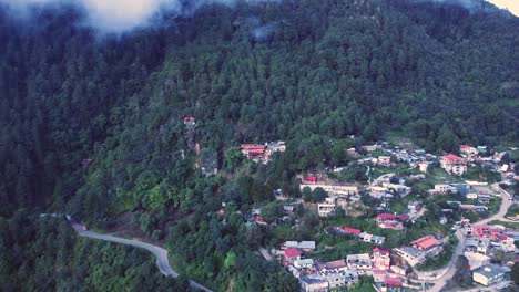 vuelo panorámico de un avión no tripulado sobre un pueblo montañoso boscoso en oaxaca, méxico