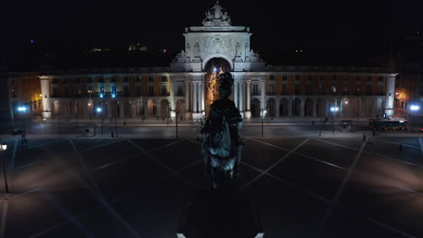 Close-up-aerial-view-of-Arco-da-Rua-Augusta-monument-and-houses-in-urban-city-center-of-Lisbon,-Portugal-at-night