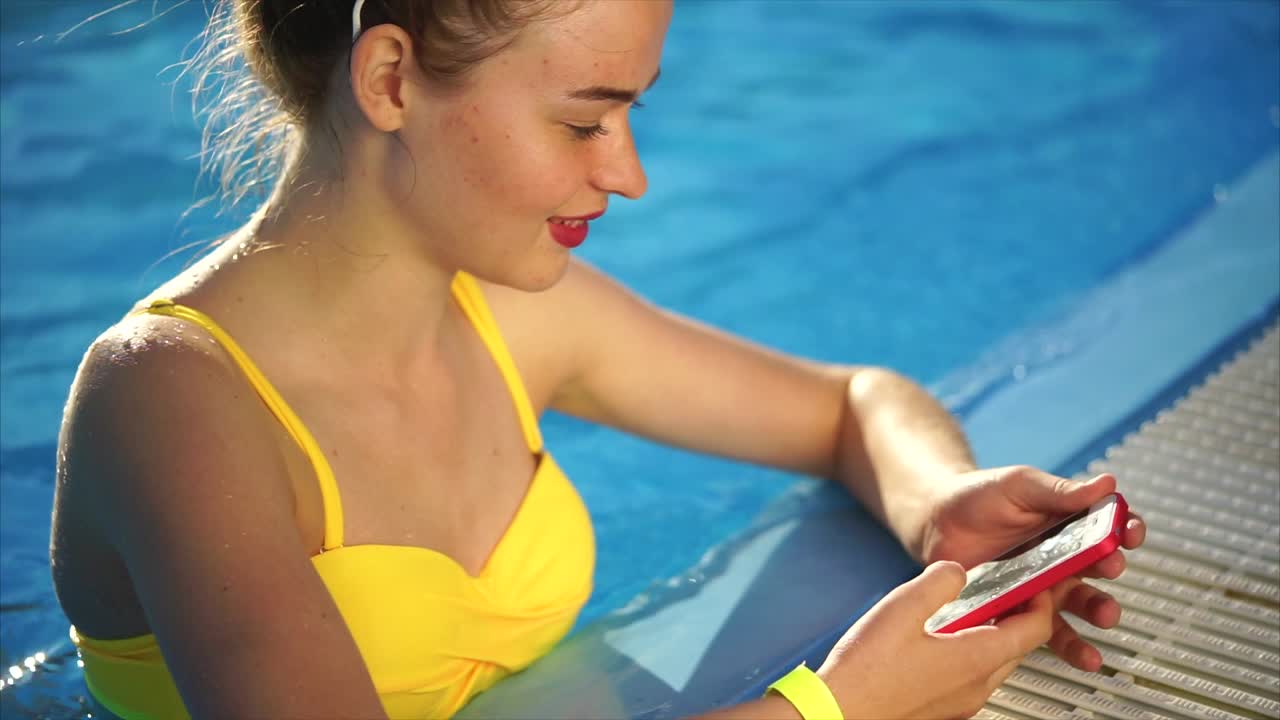 Teenager using a phone by the pool
