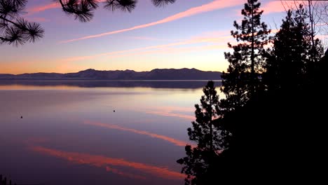 amazing orange jet contrails are reflected on the placid lake surface of lake tahoe, california, nevada