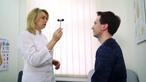 doctor examining a patient with a reflex hammer