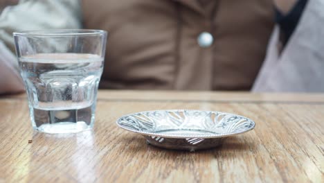 closeup of a hand holding a cup of turkish coffee in a cafe