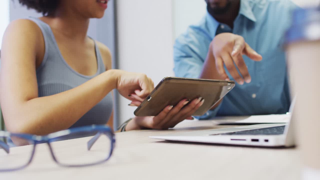 video de la sección media de un hombre de negocios diverso y una diseñadora trabajando con una tableta