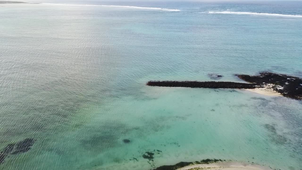 vista aérea de una isla con palmeras y playa hacia el mar