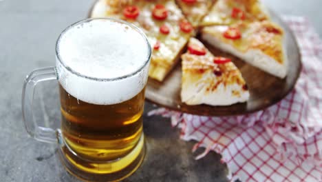 una deliciosa pizza con un vaso de cerveza