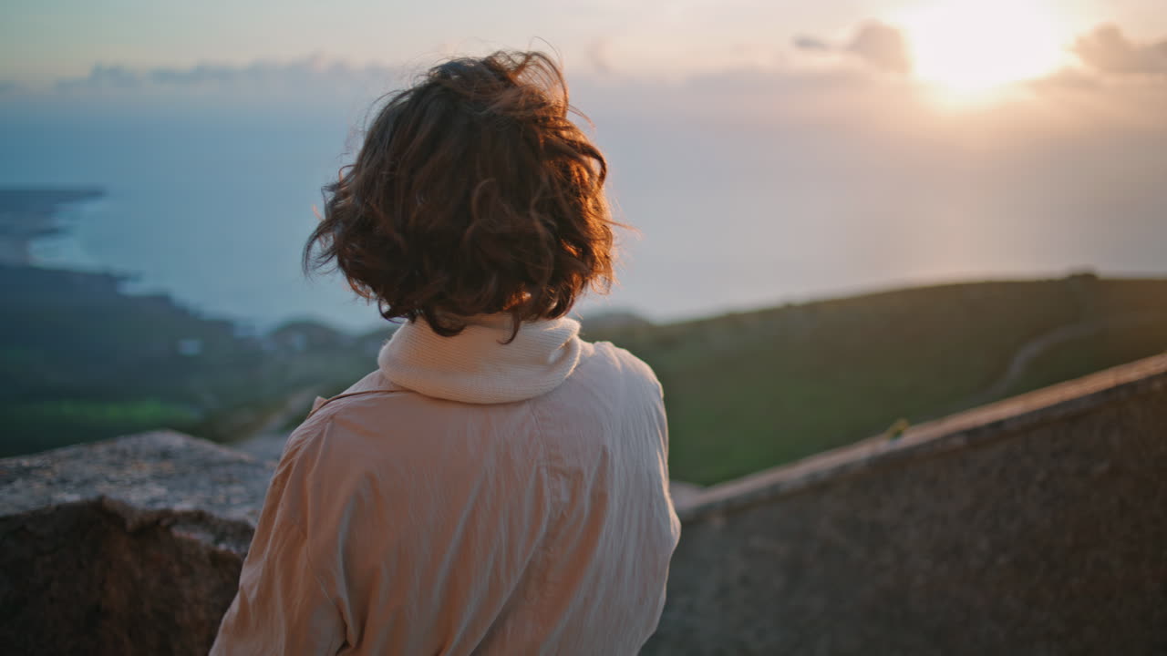 turista contemplando el paisaje del atardecer en un fin de semana ventoso de primer plano. mujer elegante