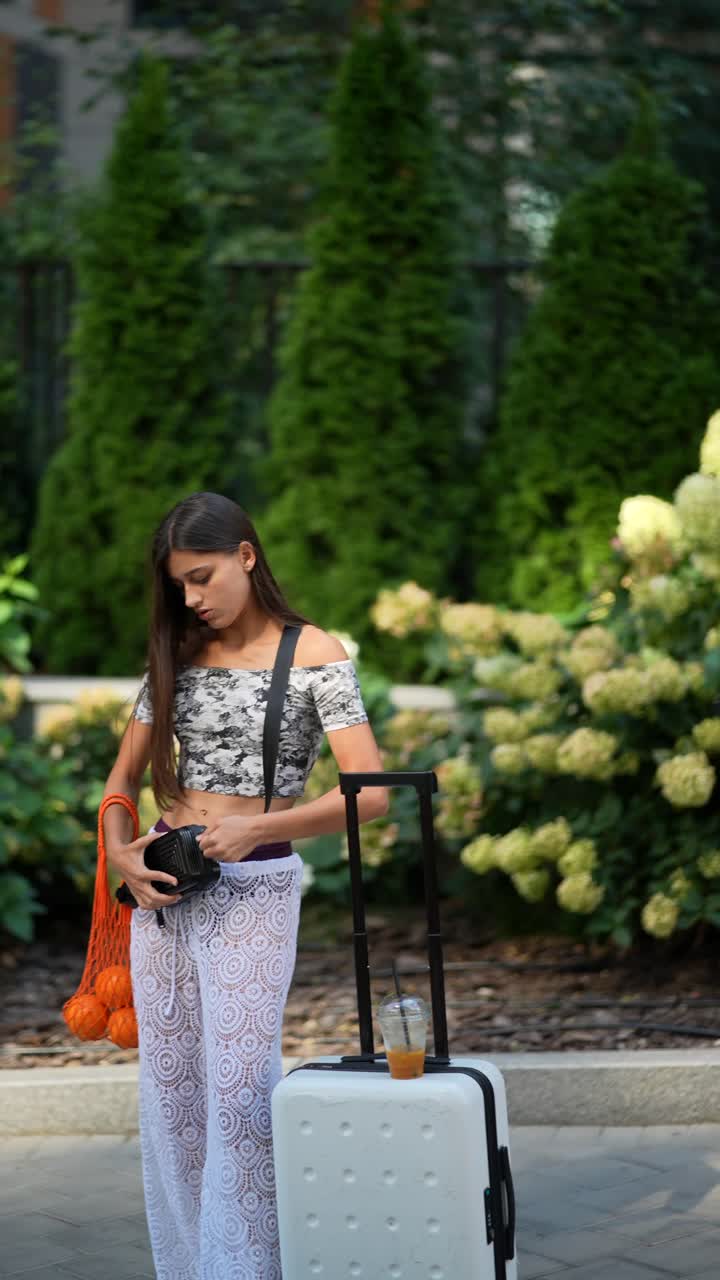 mujer con equipaje en un parque de la ciudad