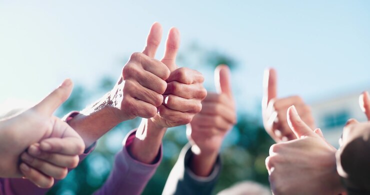 Gruppo di persone diverse che fanno il pollice in su insieme