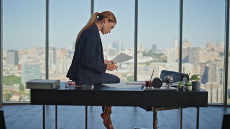 busy lawyer checking paper at panoramic window. corporate manager sitting desk