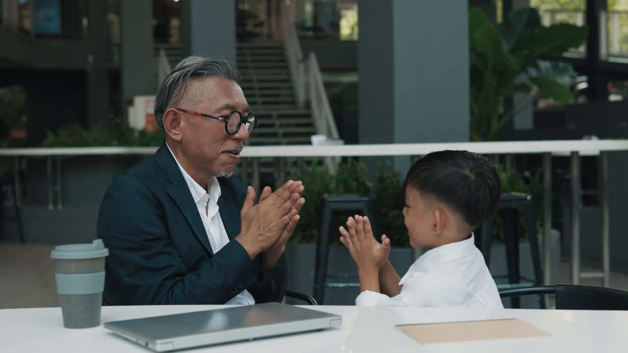Grandfather and Grandson Interacting at a Table