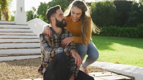 video de una feliz pareja caucásica vestida cálidamente pasando tiempo en el jardín