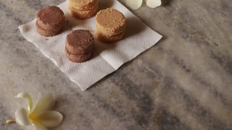 plate full of oatmeal cookies with sesame seeds being snatched up by four children