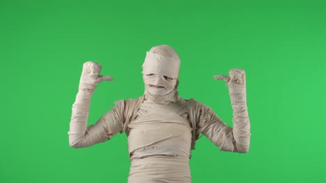 person dressed as a mummy pointing to themselves on a green screen