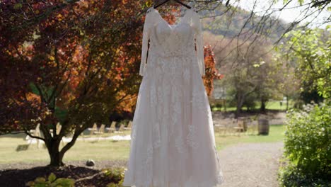 wedding-dress-hanging-in-tree-before-wedding-with-sunflare