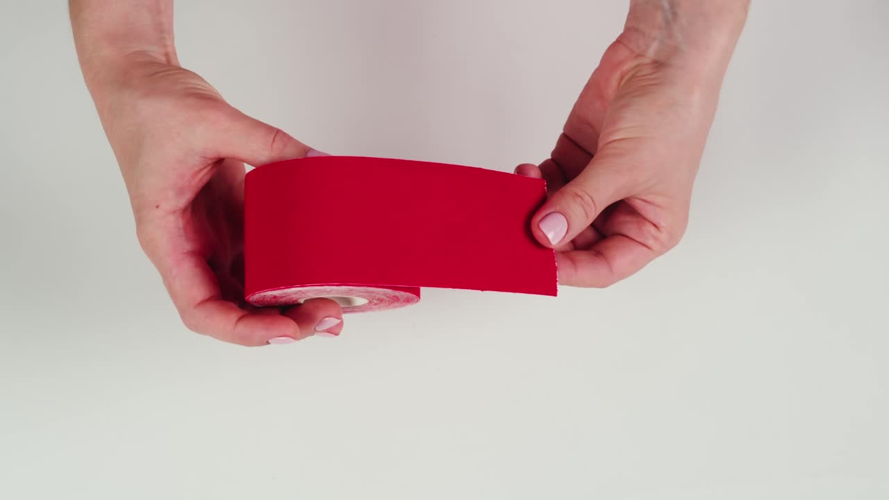 Kinesiology medical taping, doctor Physical therapist applying elastic surgical tape to patient body, treating injured knee young athlete.Post traumatic rehabilitation, sport physical therapy recovery