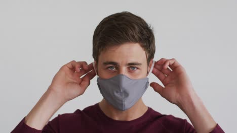 portrait of caucasian man putting mask on