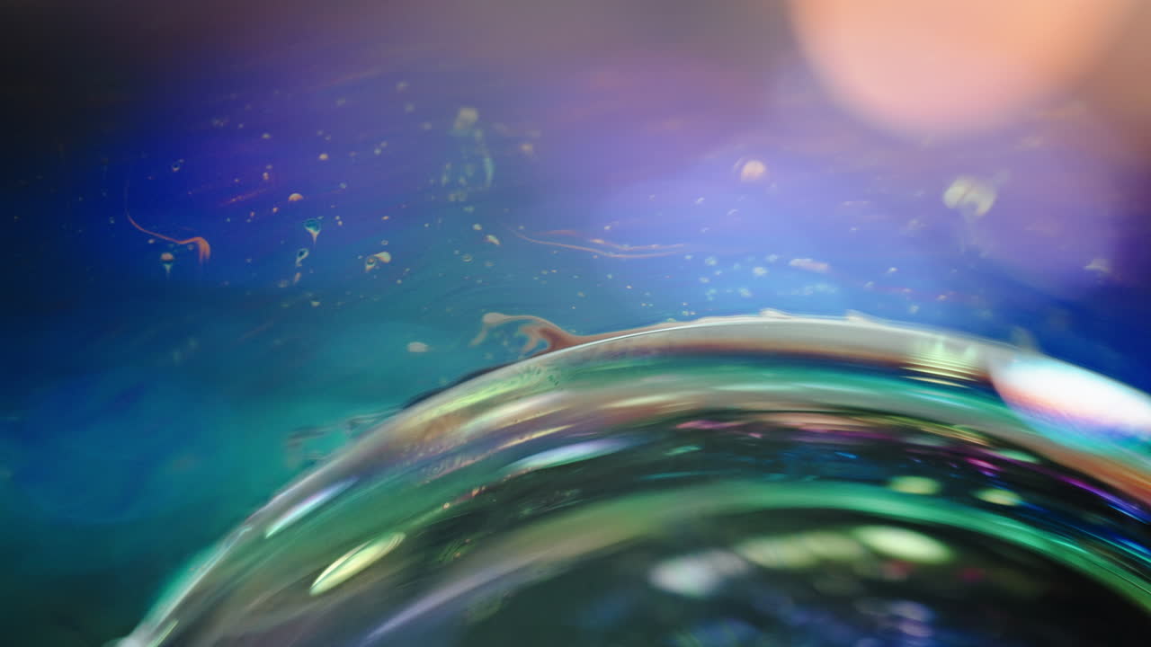 Abstract macro shot of a soap bubble with vibrant colors and cosmic reflections