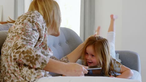 mother playing with her daughter in living room 4k