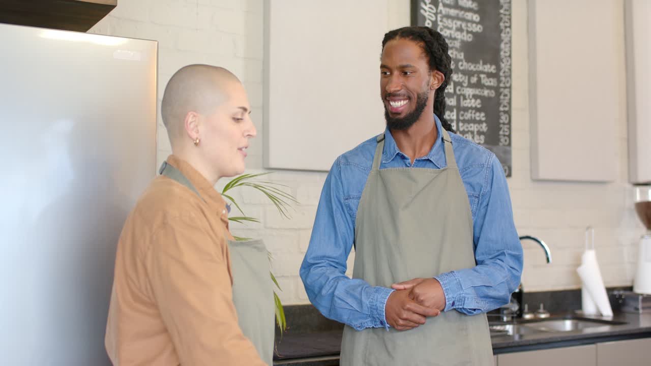 Diversi baristi che guardano dritto negli occhi una donna mentre spiega una ricetta, gesticolando dietro il bancone del bar