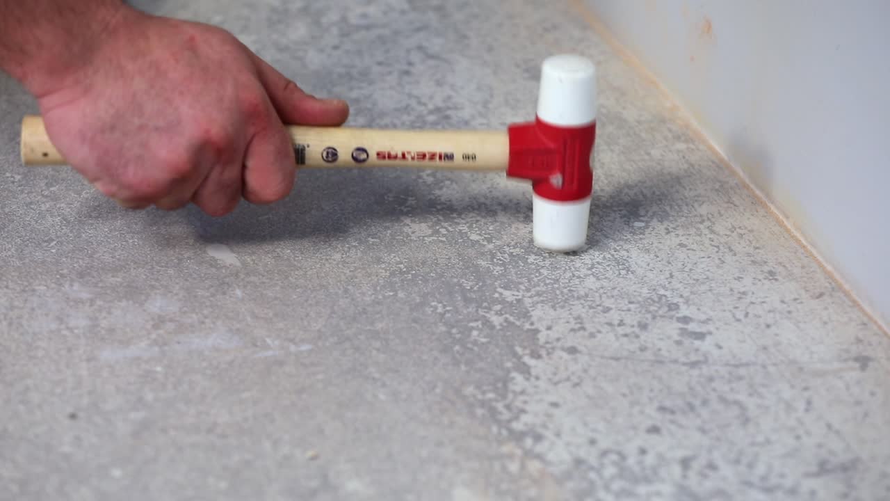 el trabajador está martillando clavijas de plástico en cámara lenta