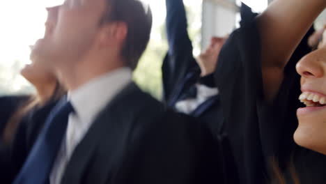 Students-At-Graduation-Ceremony-Throwing-Hats-In-The-Air