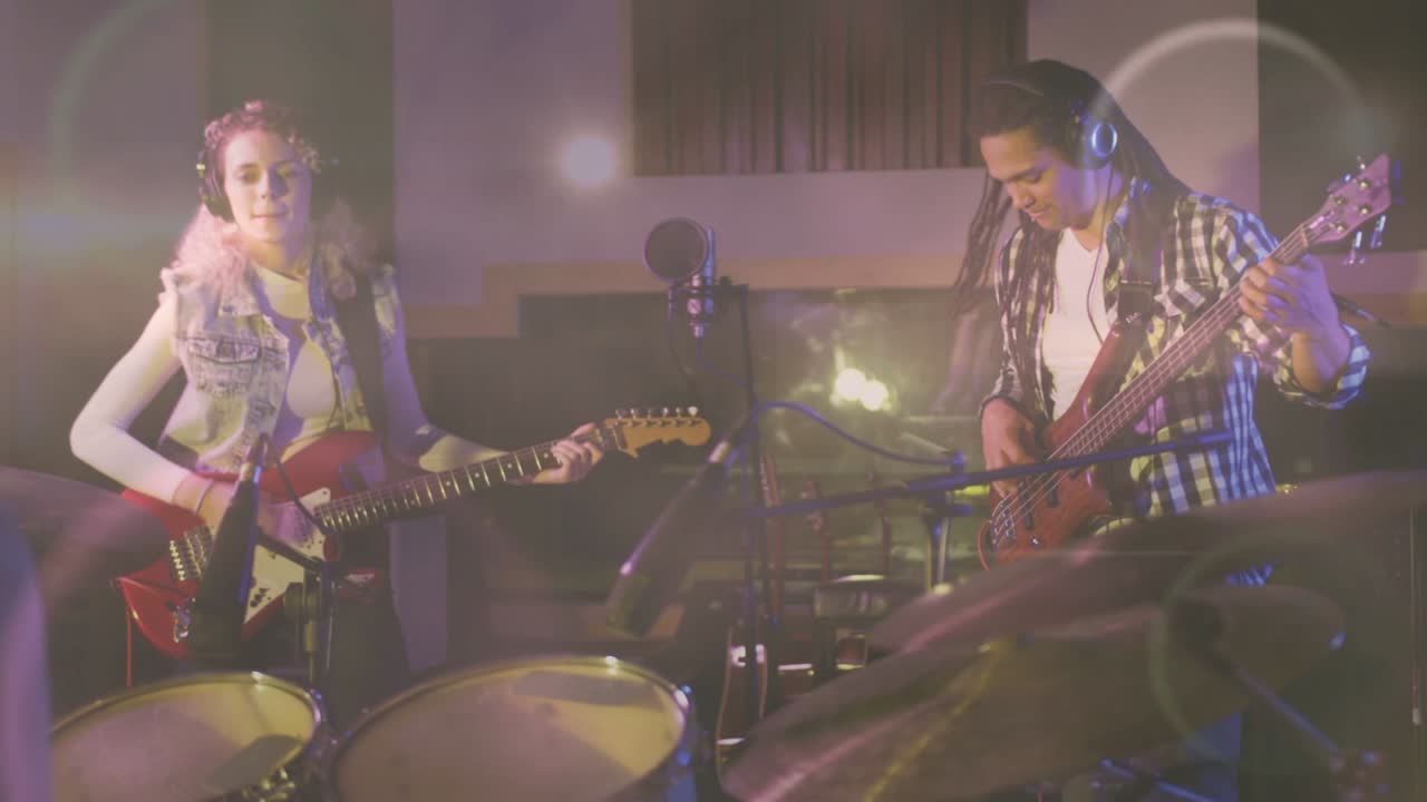 On cue guitarist fretting and strumming, bassist plucking, recording with animated bokeh on cymbals