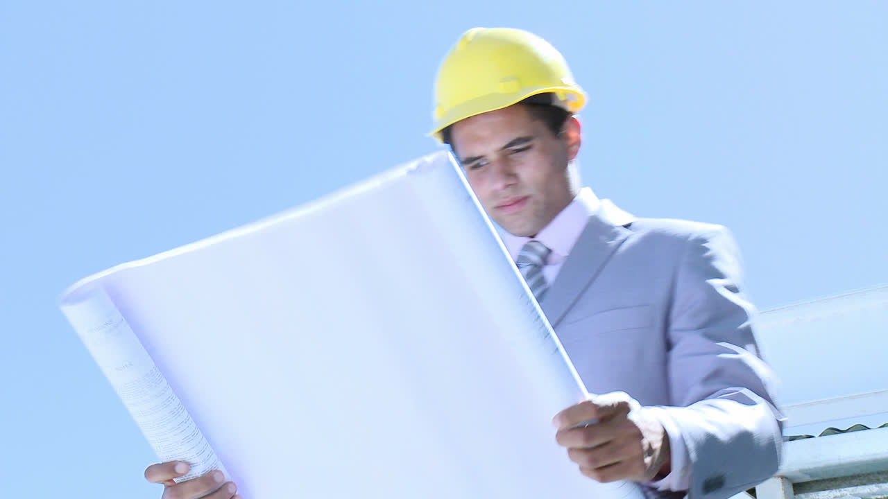 arquitecto que tiene los planos comprobando las obras