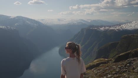 a woman enjoys a breathtaking view from mount prest in norway