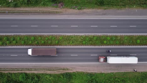 Vista-Aérea-De-Arriba-Hacia-Abajo-De-Una-Carretera-De-Cuatro-Carriles-En-India-Con-Peatones,-Motocicletas,-Automóviles-De-Pasajeros-Y-Camiones-De-Carga-Pasando