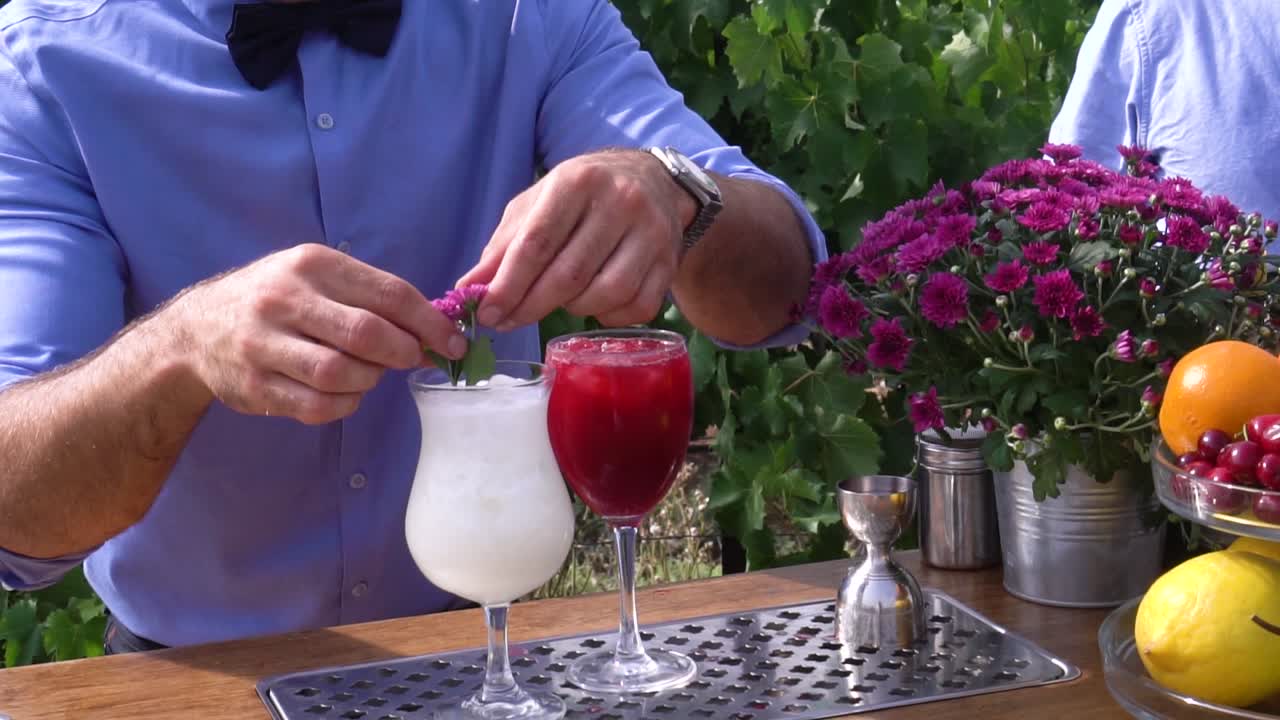 Barmen putting a flower in a cocktail