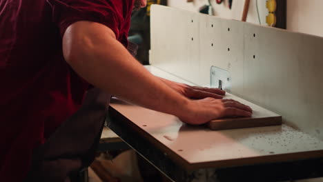 machinist with protection gear inserting plank in spindle moulder