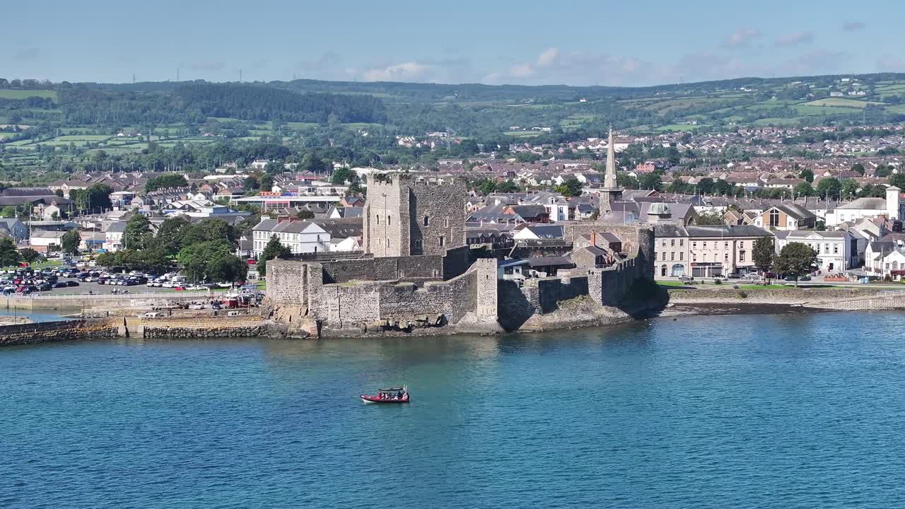Carrickfergus Castle in County Antrim Northern Ireland. Part of the Causeway Coastal Route. Aerial 50fps UHD