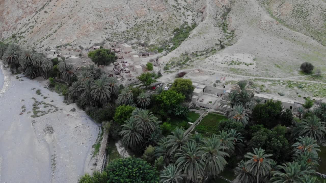 vista aérea del pueblo ubicado en khuzdar con exuberantes árboles verdes y jardines rodeados por un paisaje desértico