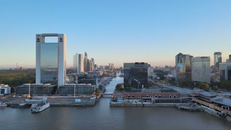 aerial dolly in from north dock of puerto madero toward the waterfront high rise buildings and straight downtown waterway at the central business district of buenos aires