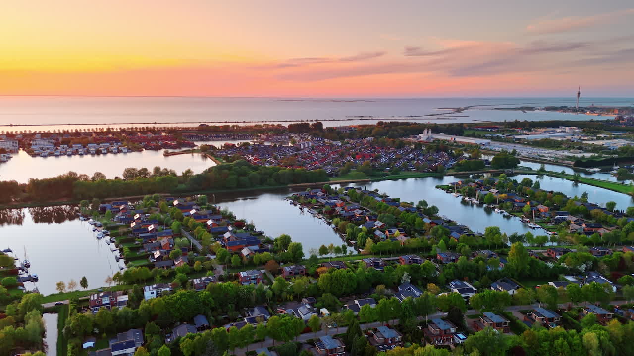 Colorful sunset over Dutch lakes. A serene sunset view showcases calm waters and charming houses in the Netherlands, reflecting nature's beauty at dusk