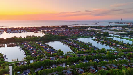 colorful sunset over dutch lakes. a serene sunset view showcases calm waters and charming houses in the netherlands, reflecting nature's beauty at dusk