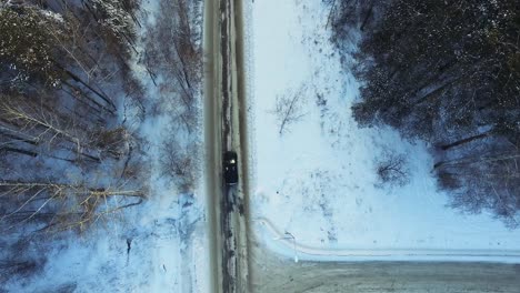 snowy forest road with car