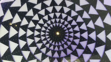 abstract pattern of black and white circles and triangles moving clockwise