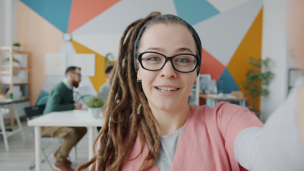 Donna che si fa un selfie in un ufficio moderno.