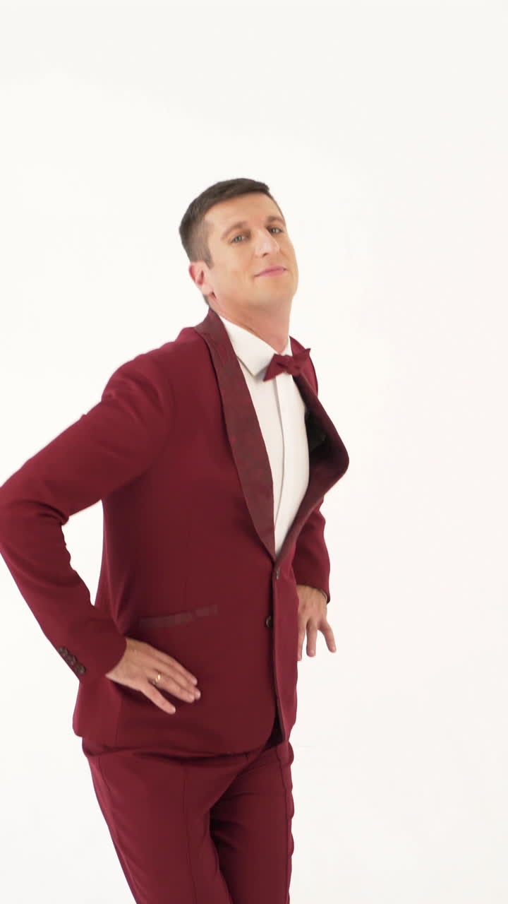 cheerful man in a red suit is making exercises with his hands on the sides on a white background. Caricature of a man who doing physical exercises Vertical video