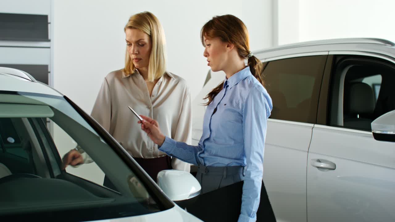 vendedora de coches mostrando el coche al cliente