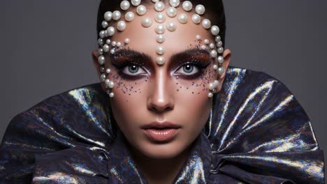 stunning transformation: a close-up look at an avant-garde makeup concept, featuring pearls and sparkles that create a dazzling artistic statement